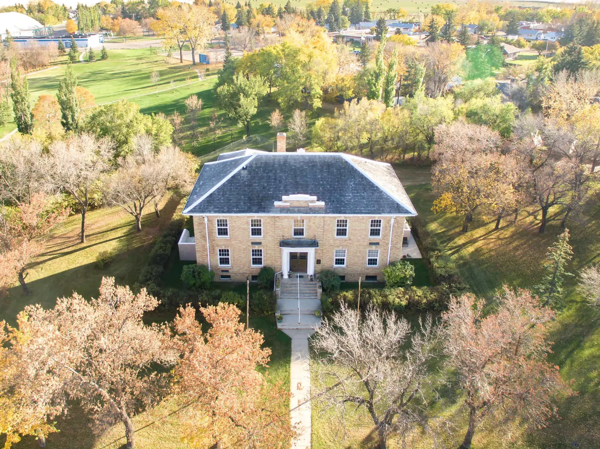 Aerial view of the 1930 Assiniboia Court House in autumn — a two-storey brick heritage building at 700 Centre Street