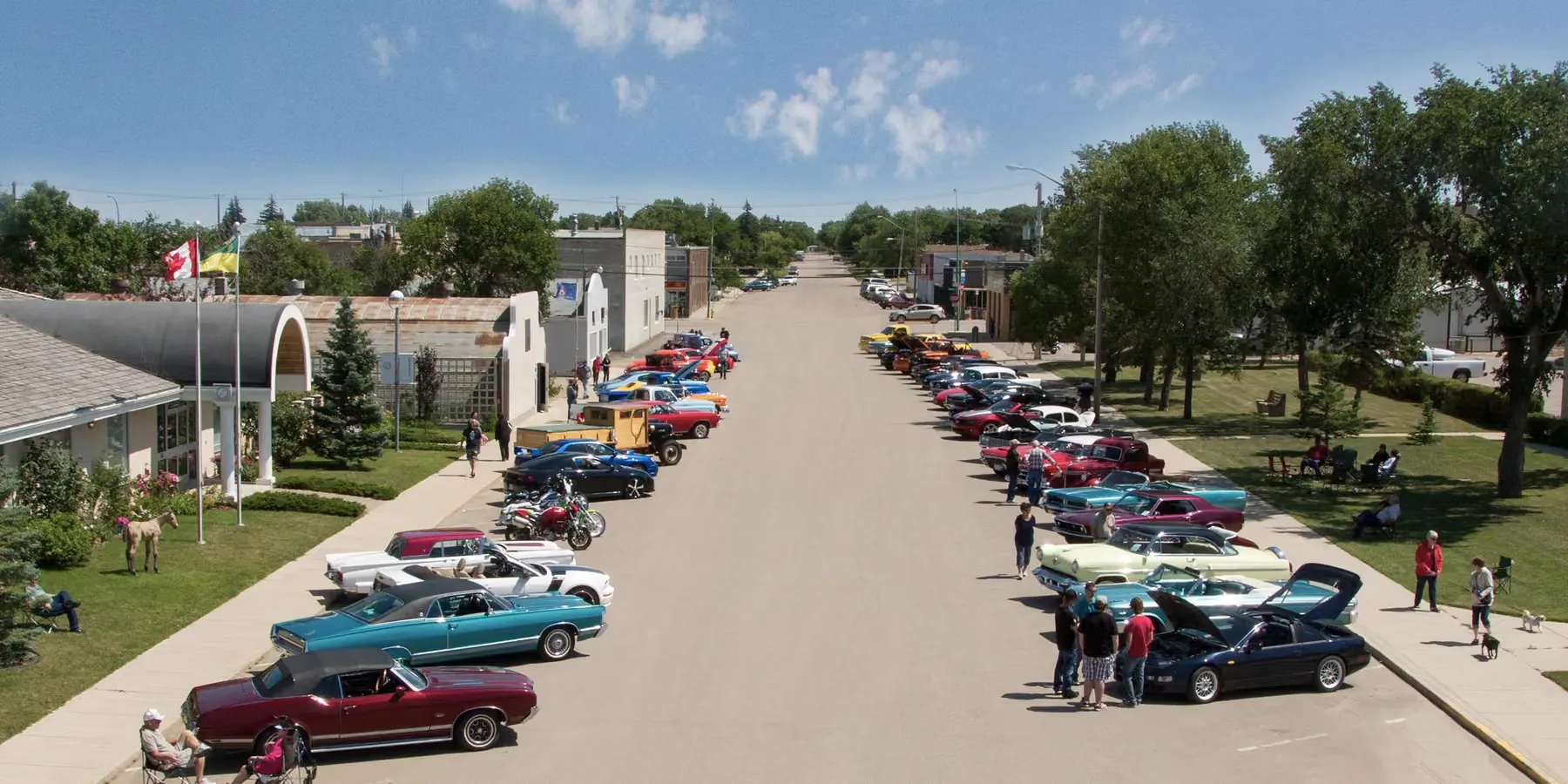 Classic cars lined up under the flags at the Main Street car show in downtown Assiniboia