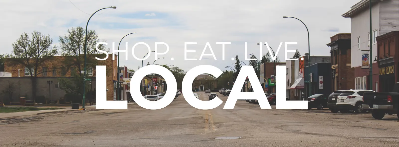 Shop. Eat. Live. LOCAL — the Chamber of Commerce banner graphic over Assiniboia's main street